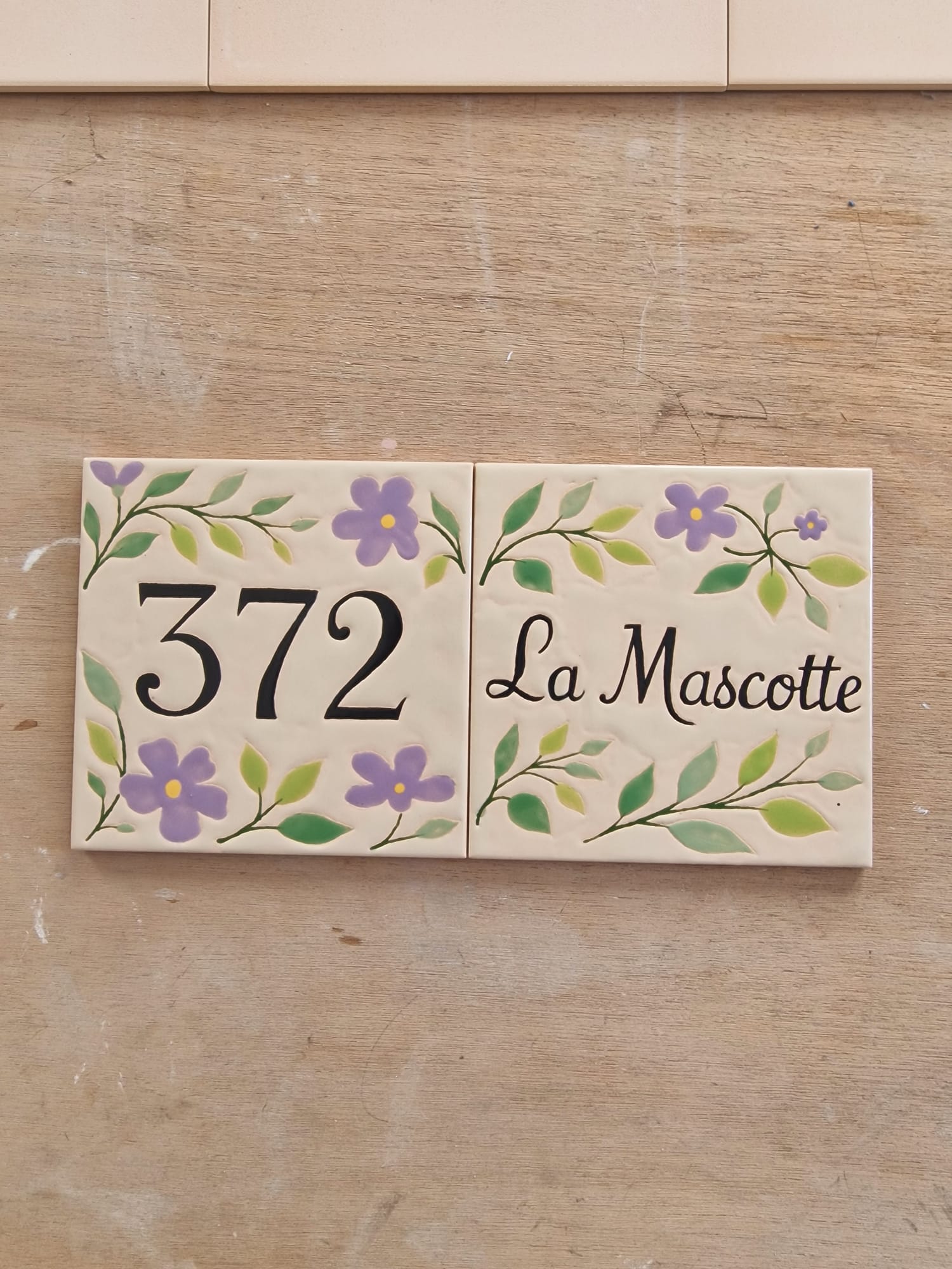 372 La Mascotte  ·  numéro et nom réunis sur deux carreaux fleuris.